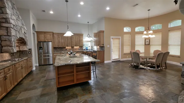 a kitchen with stainless steel appliances granite countertop a stove a sink a oven a dining table and chairs