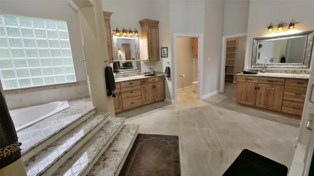 a spacious bathroom with a double vanity sink a mirror and a bathtub