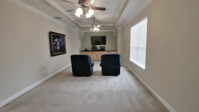 a large room with windows and a ceiling fan
