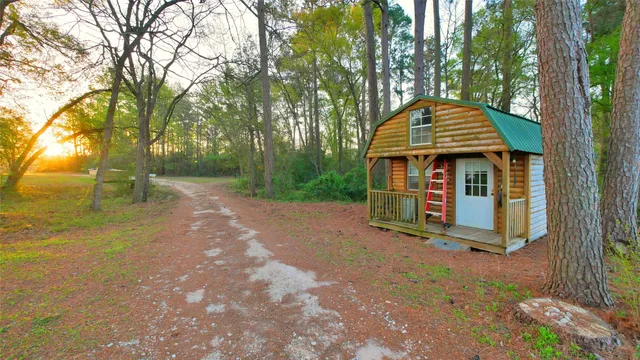 a view of a small house with large trees