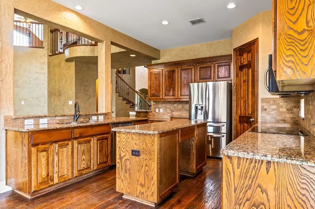a kitchen with stainless steel appliances granite countertop a stove and a refrigerator