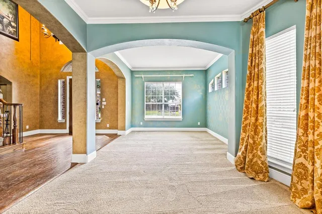 a view of a hallway with wooden floor and a window
