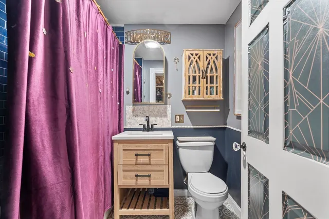 a bathroom with a toilet a sink and a mirror