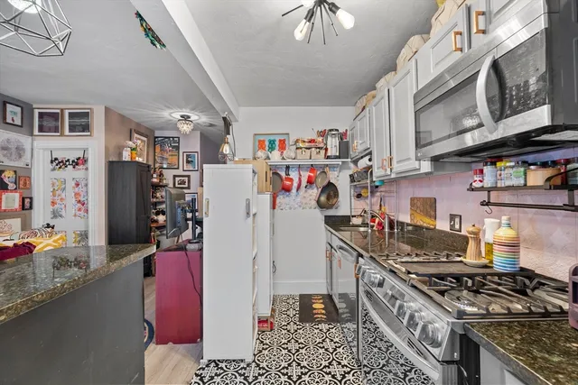 a kitchen with stainless steel appliances granite countertop a stove and cabinets