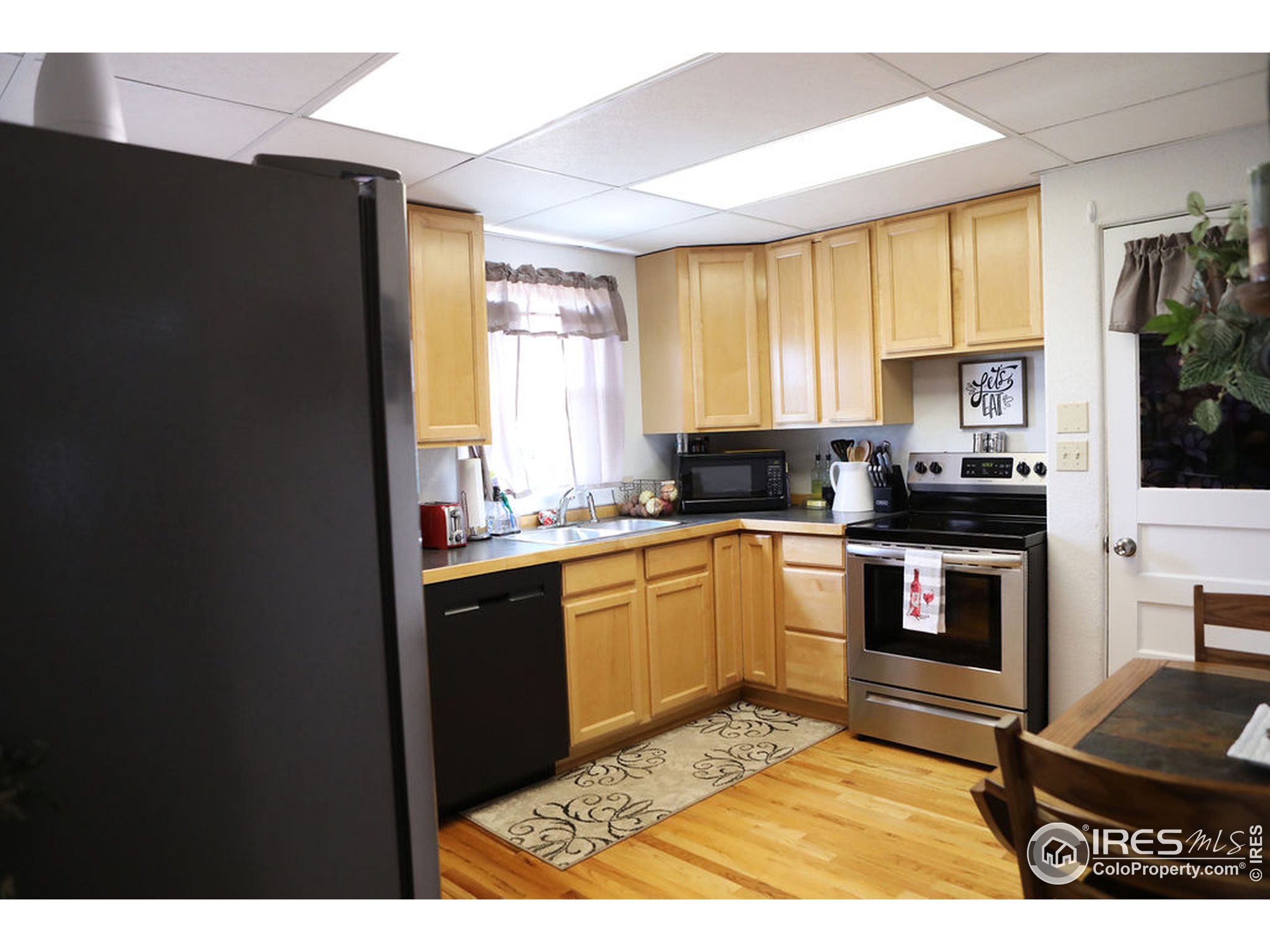 1150 County Rd M 5/10 Wiggins, CO 80654 - Photo 6 of 31 a kitchen with a refrigerator and a sink
