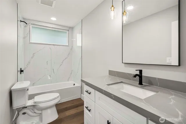 a bathroom with a sink a toilet and shower