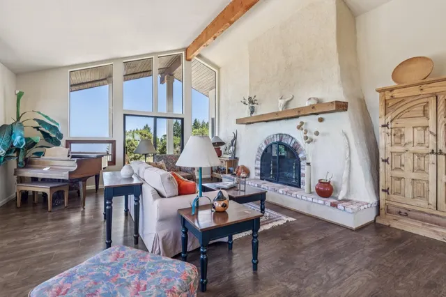a living room with furniture a fireplace and a floor to ceiling window