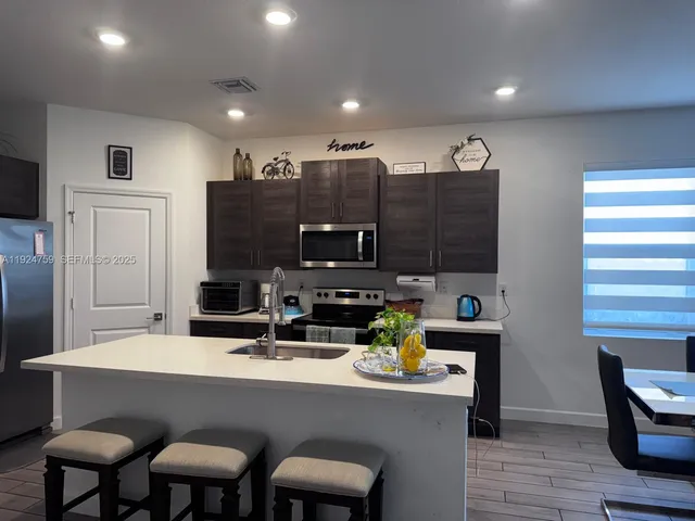 a kitchen with a sink cabinets and wooden floor
