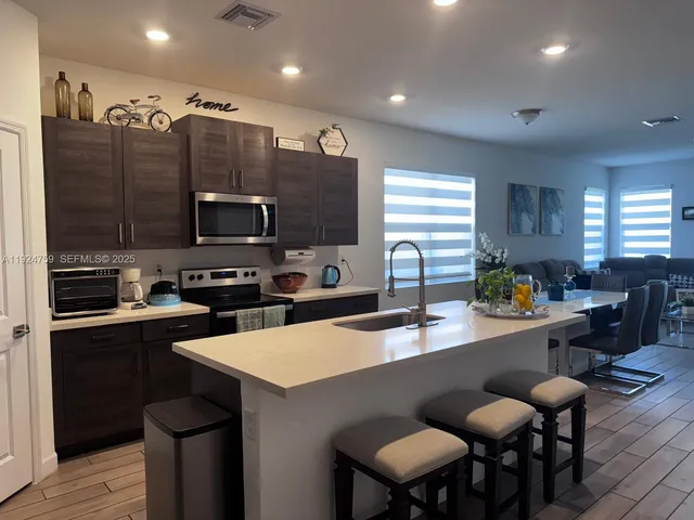 a kitchen with a sink a counter space appliances and cabinets