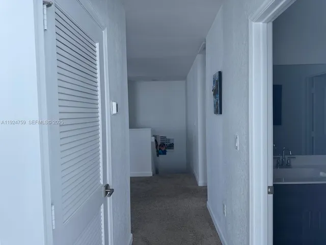a view of a hallway with closet and living room