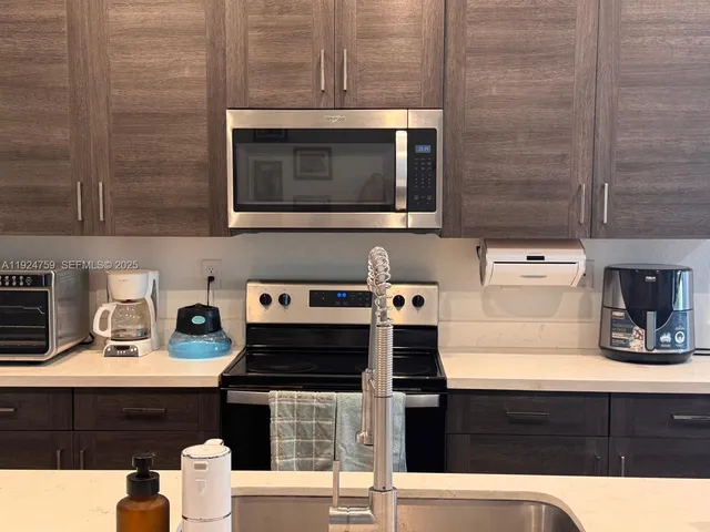 a kitchen with a sink stove and microwave