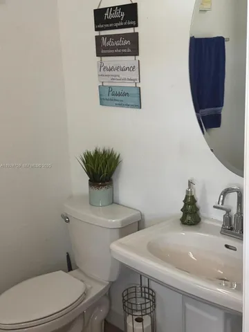 a bathroom with a toilet sink and mirror