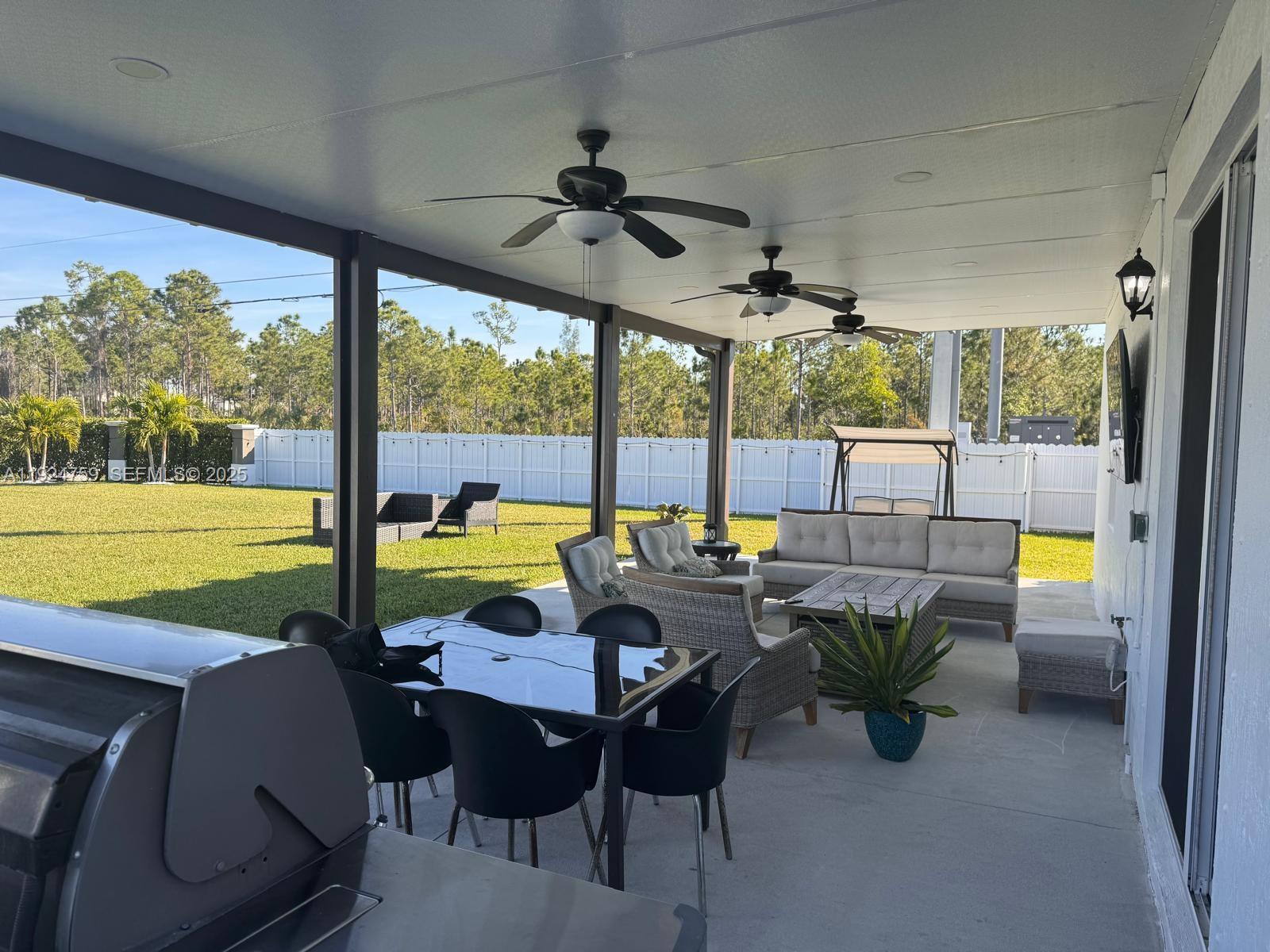 13201 Southwest 269th Terrace Homestead, FL 33032 - Photo 29 of 33 a view of a patio with a table chairs and a backyard