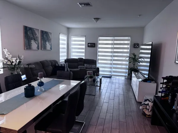 a living room with furniture and wooden floor