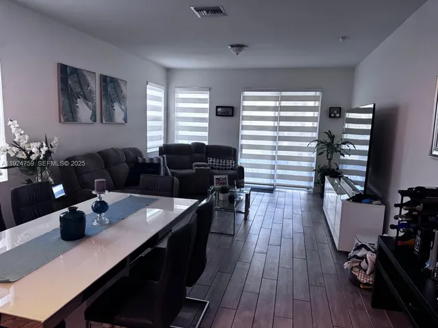 a living room with furniture and wooden floor