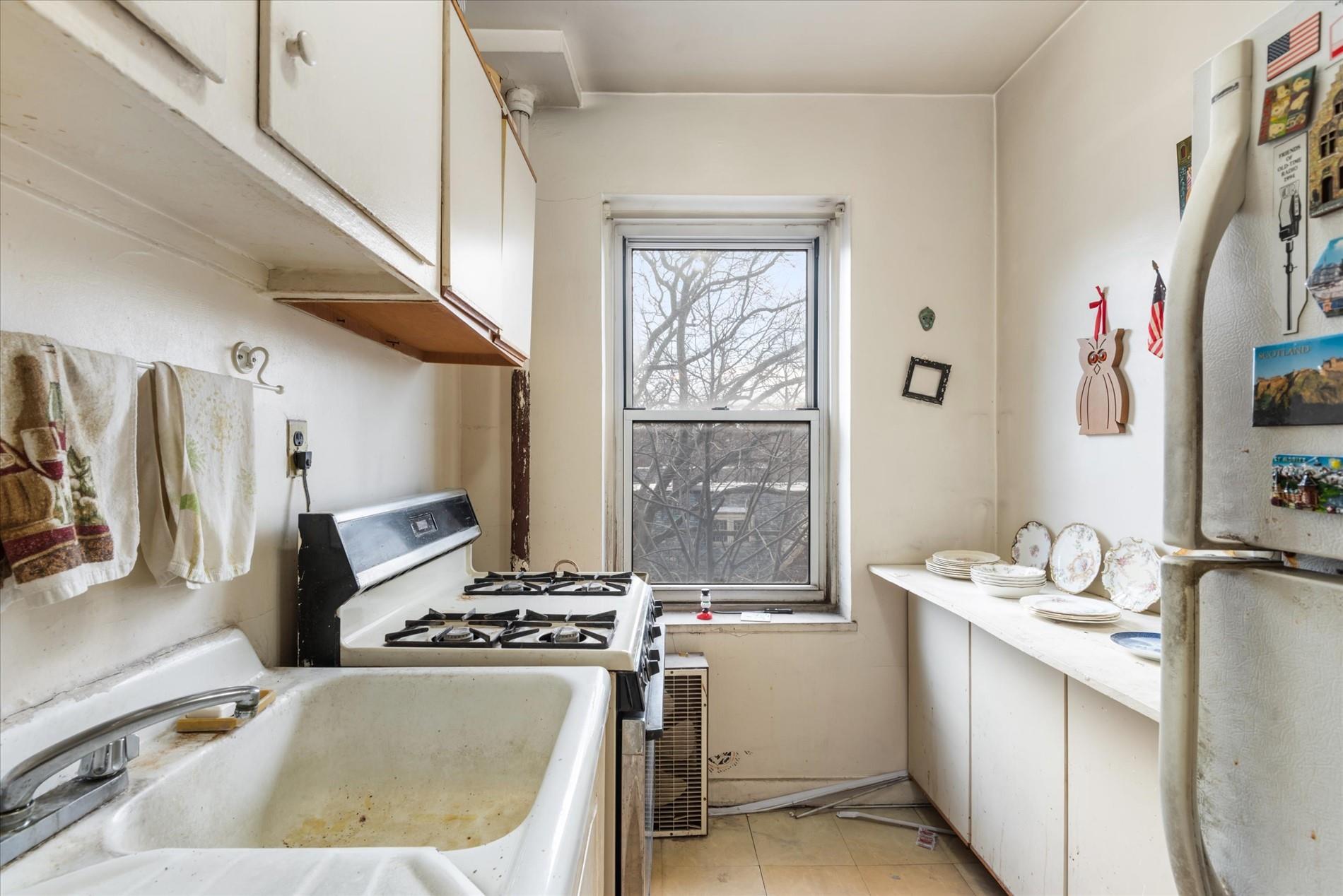 34-41 85th Street, Unit 4S Queens, NY 11372 - Photo 10 of 20 Kitchen featuring white appliances, white cabinets, a sink, and light countertops