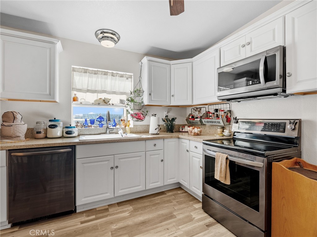 22977 El Centro Road Apple Valley, CA 92307 - Photo 13 of 30 a kitchen with stainless steel appliances granite countertop a sink and a stove