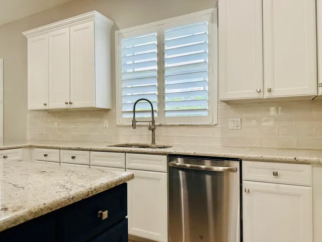 a view of an empty room with wooden floor and a bathroom