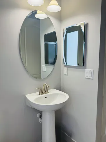 a spacious bathroom with a granite countertop sink toilet a mirror and shower