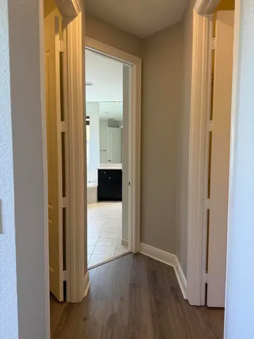 a view of a hallway with wooden floor and staircase