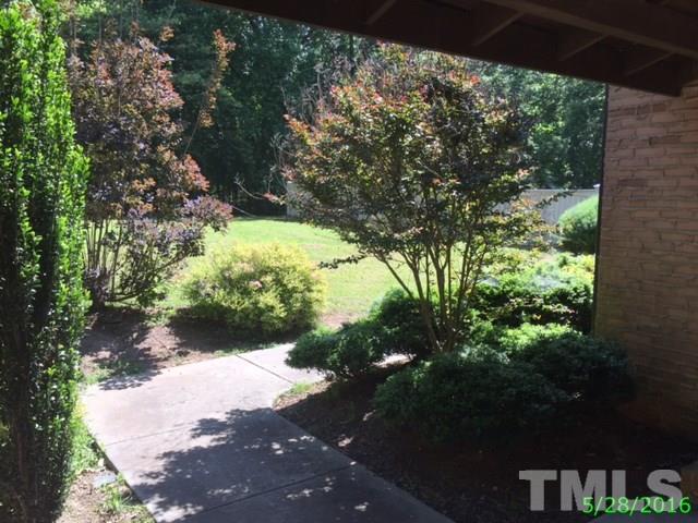 9404 Wilkins Road Bahama, NC 27503 - Photo 3 of 21 a view of a yard with plants and large trees