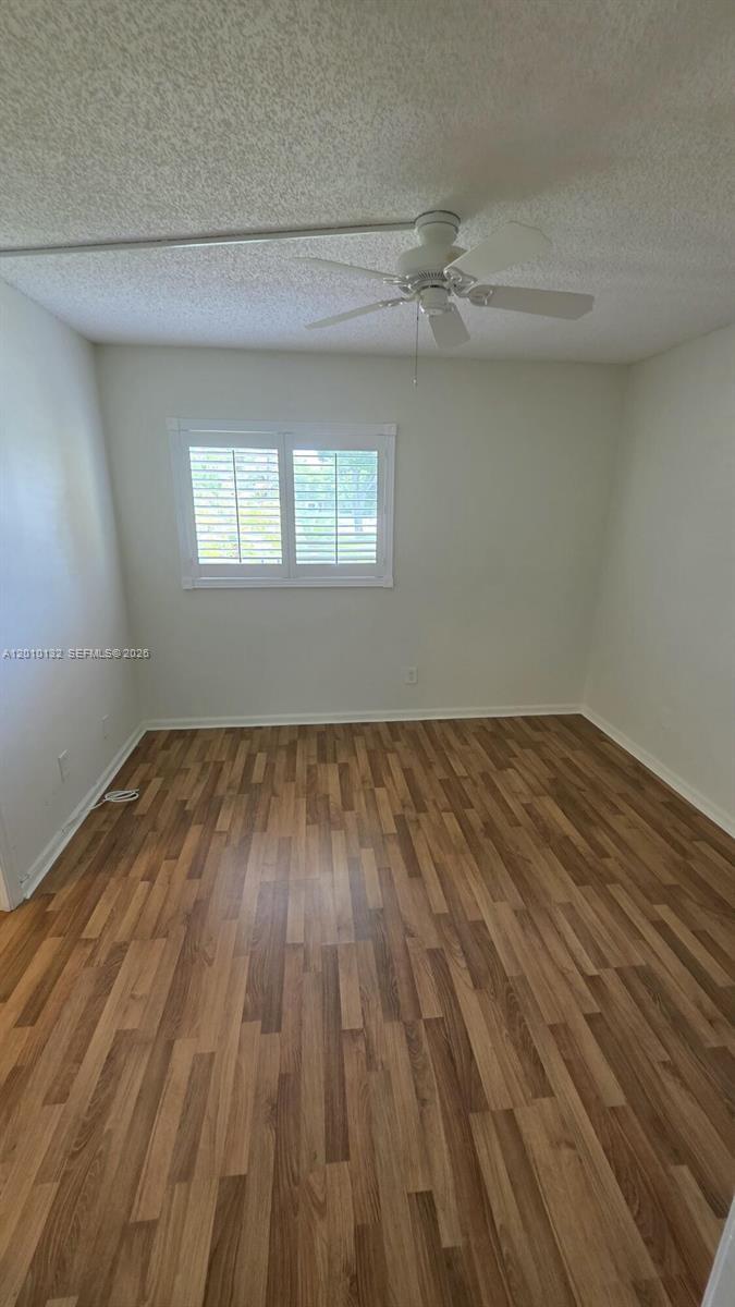 23305 Barwood Lane North, Unit 207 Boca Raton, FL 33428 - Photo 16 of 27 a view of a room with wooden floor and windows
