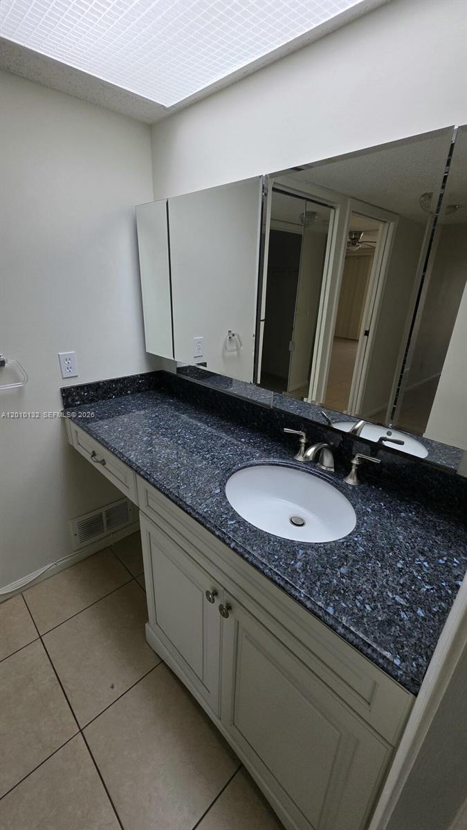 23305 Barwood Lane North, Unit 207 Boca Raton, FL 33428 - Photo 20 of 27 a bathroom with a granite countertop sink and a mirror