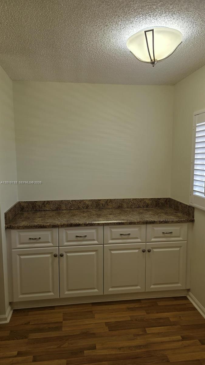 23305 Barwood Lane North, Unit 207 Boca Raton, FL 33428 - Photo 9 of 27 a view of a kitchen with wooden floor and cabinets
