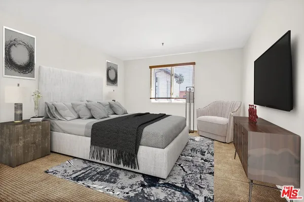 a large bed sitting in a bedroom next to a window