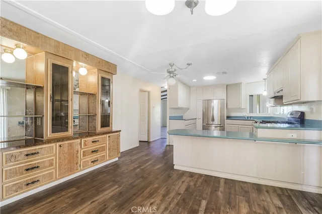 a large kitchen with kitchen island a large counter space a sink appliances and cabinets