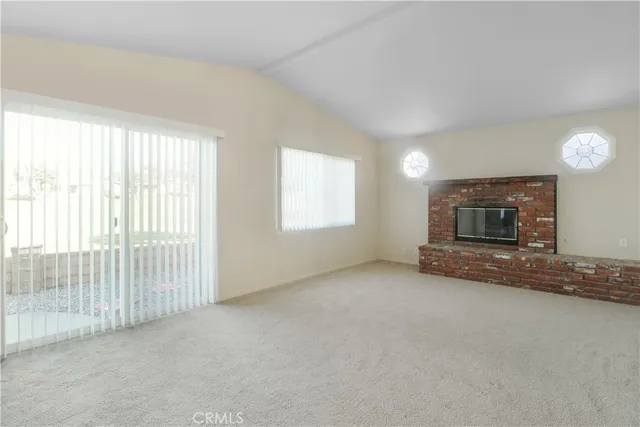 an empty room with fireplace and windows