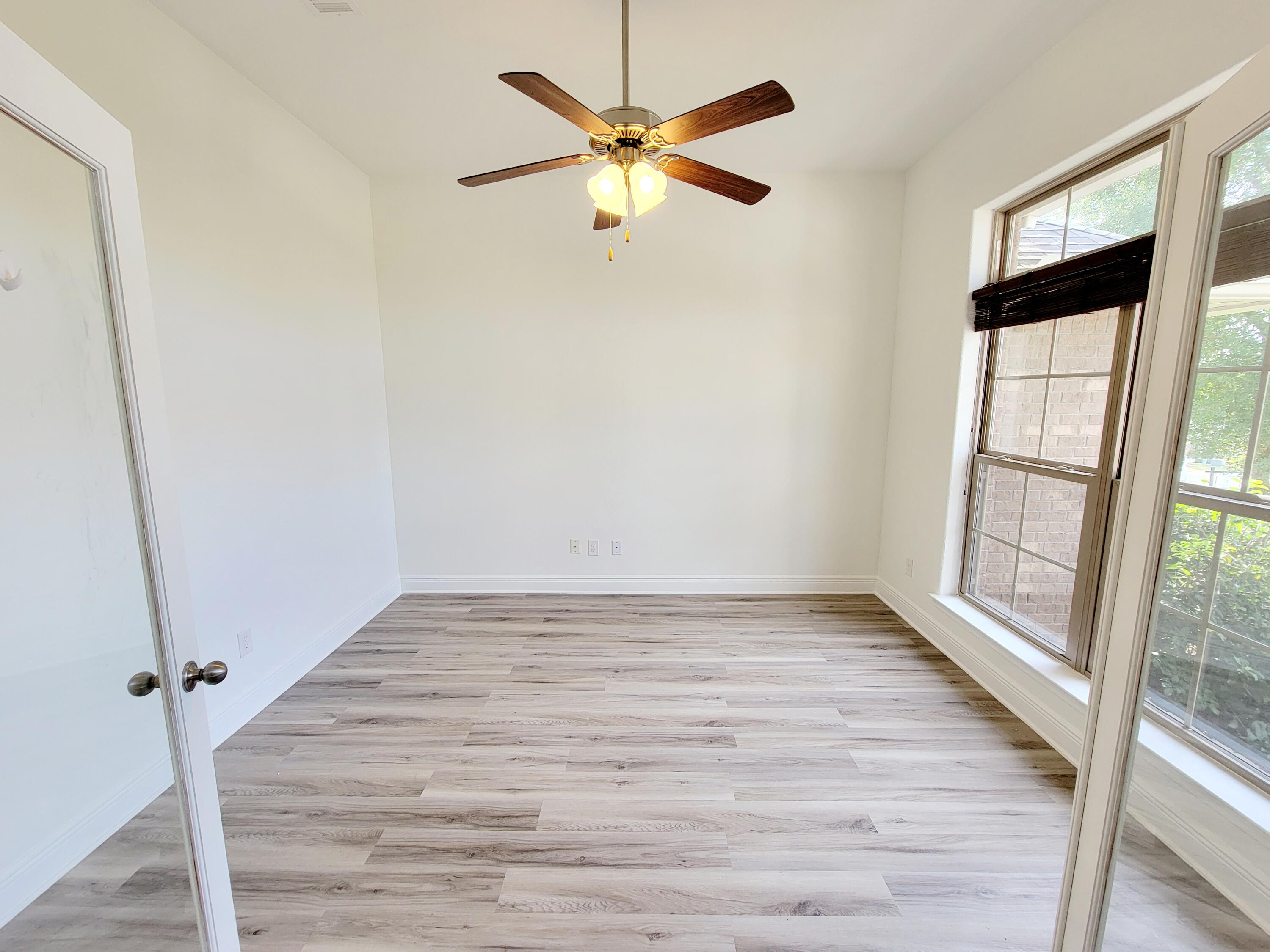 505 Vale Loop Crestview, FL 32536 - Photo 4 of 14 an empty room with wooden floor and windows