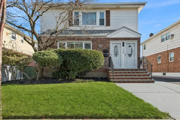 a front view of a house with a garden