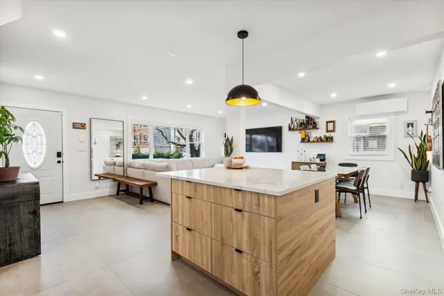 a kitchen with stainless steel appliances kitchen island granite countertop a sink and a refrigerator