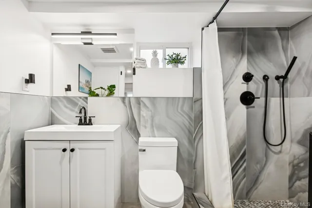 a bathroom with a sink toilet and shower