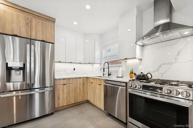 a kitchen with stainless steel appliances white cabinets and a refrigerator