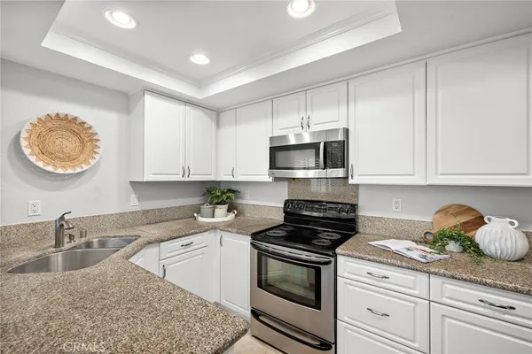 a kitchen with stainless steel appliances granite countertop a sink a stove and a microwave