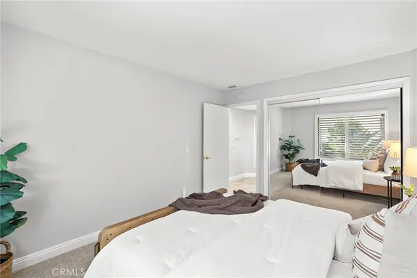 a bedroom with a bed and large windows