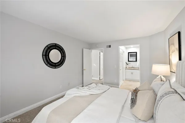 a bedroom with a bed and white cabinets