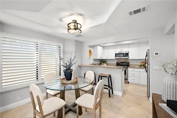 a kitchen with a table chairs a stove a dining table and chairs