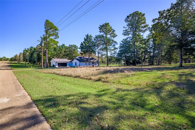 an aerial view of residential house with outdoor space and trees all around