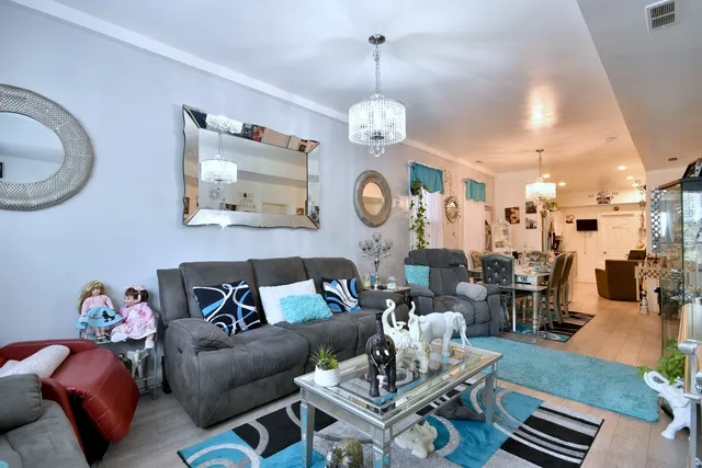 a living room with furniture a dining table and paintings on the wall