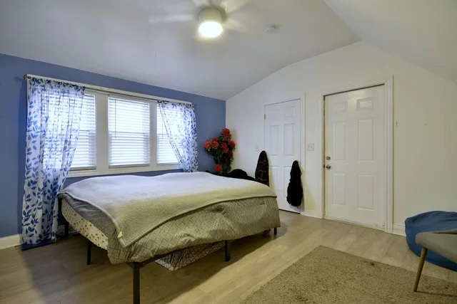 a bed sitting in a spacious bedroom next to a window