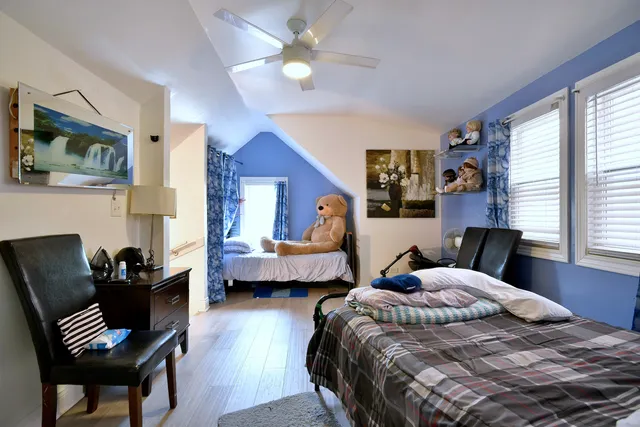 a bedroom with a bed wooden floor and window