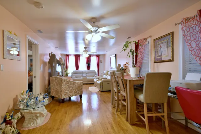 a living room with furniture kitchen view and a chandelier