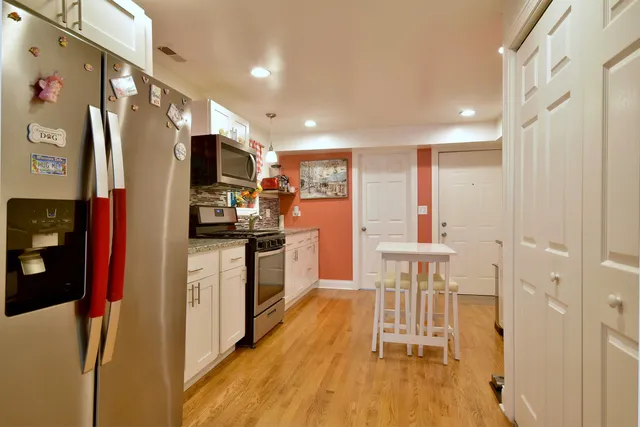 a kitchen with stainless steel appliances kitchen island granite countertop a refrigerator and a stove top oven
