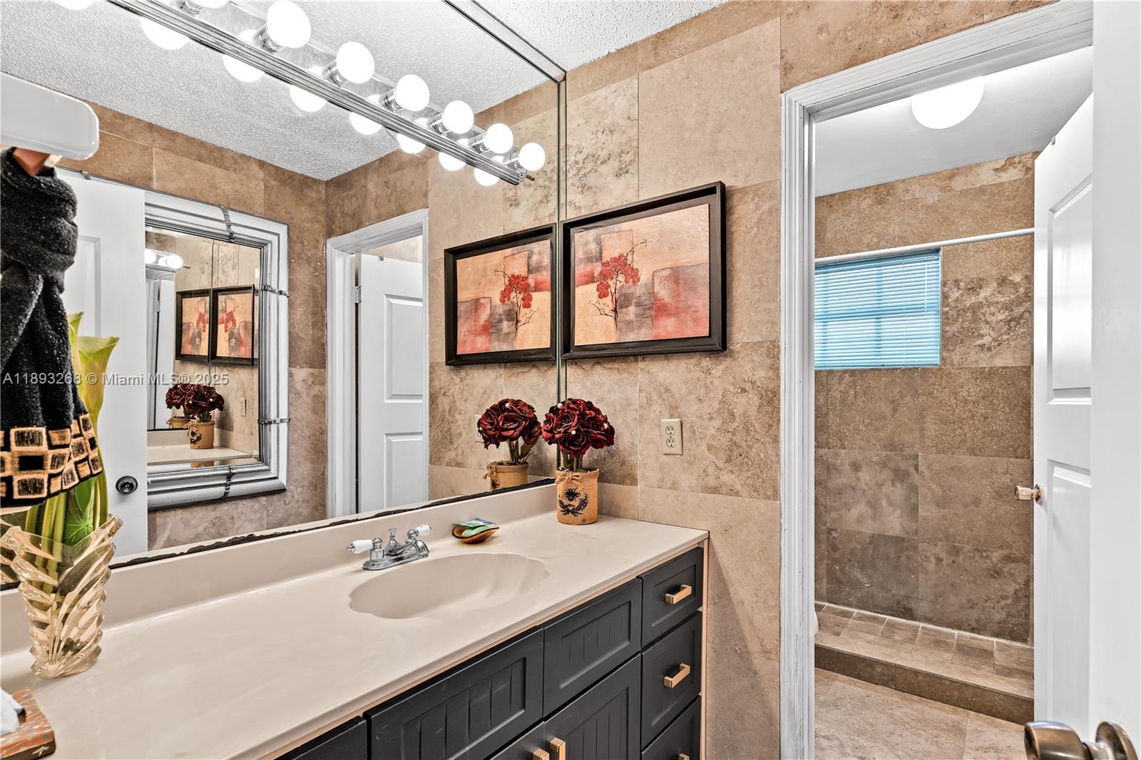 8909 Southwest 108th Circle Miami, FL 33176 - Photo 16 of 28 a bathroom with a sink a mirror and a shower