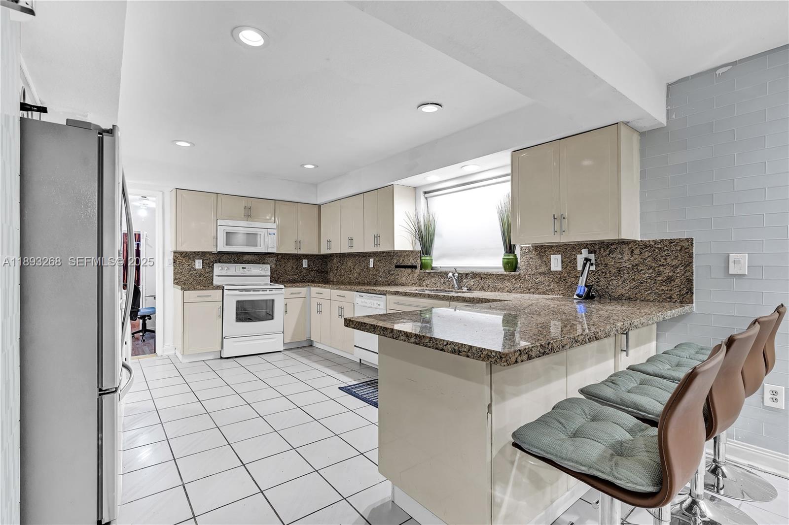 8909 Southwest 108th Circle Miami, FL 33176 - Photo 8 of 28 a kitchen with stainless steel appliances granite countertop a stove a sink and a refrigerator