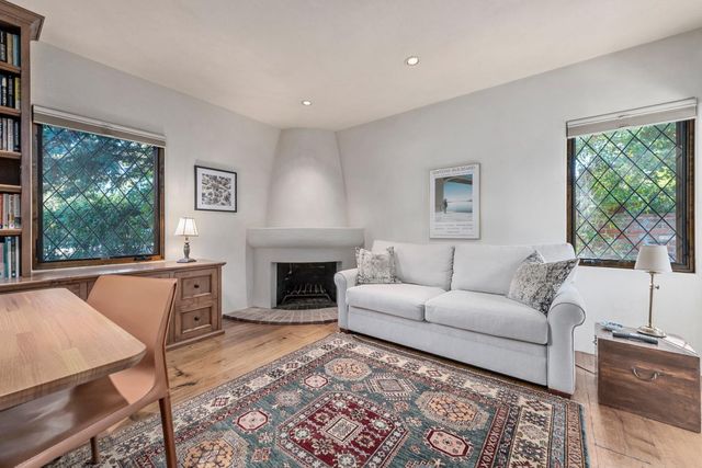 a living room with furniture a large window and a fireplace