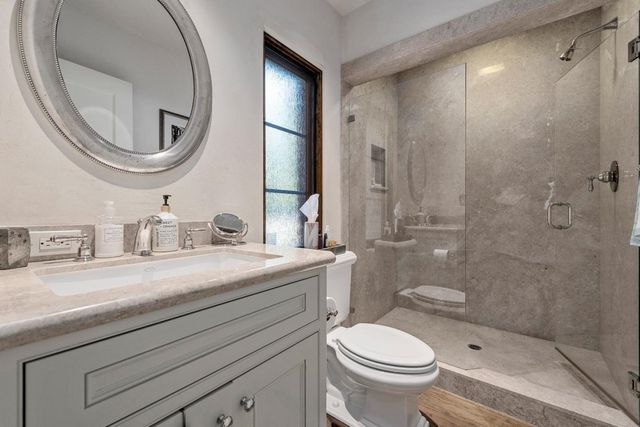 a bathroom with a sink a toilet and a mirror